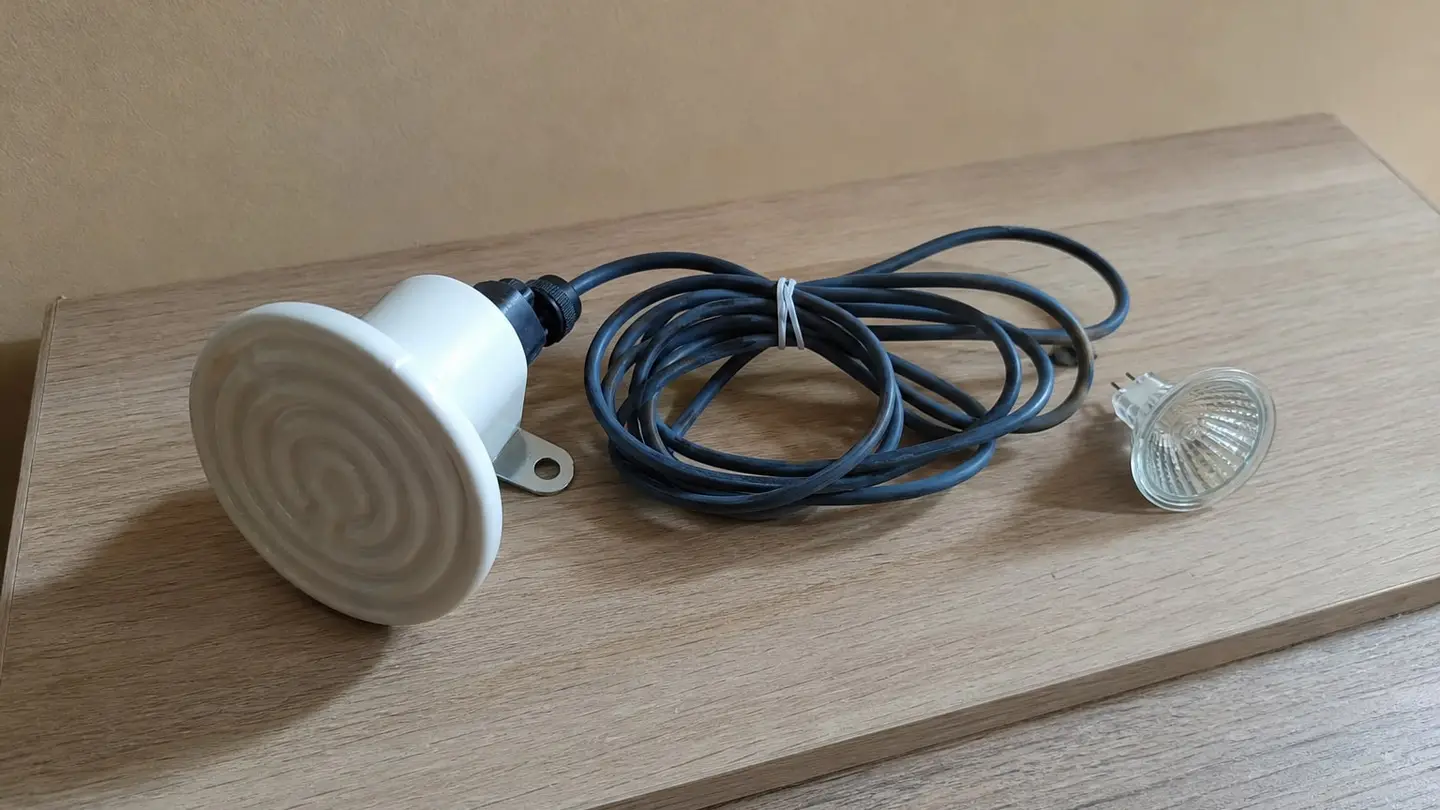 Ceramiczny emiter podczerwieni i wyłączona żarówka halogenowa na drewnianym blacie